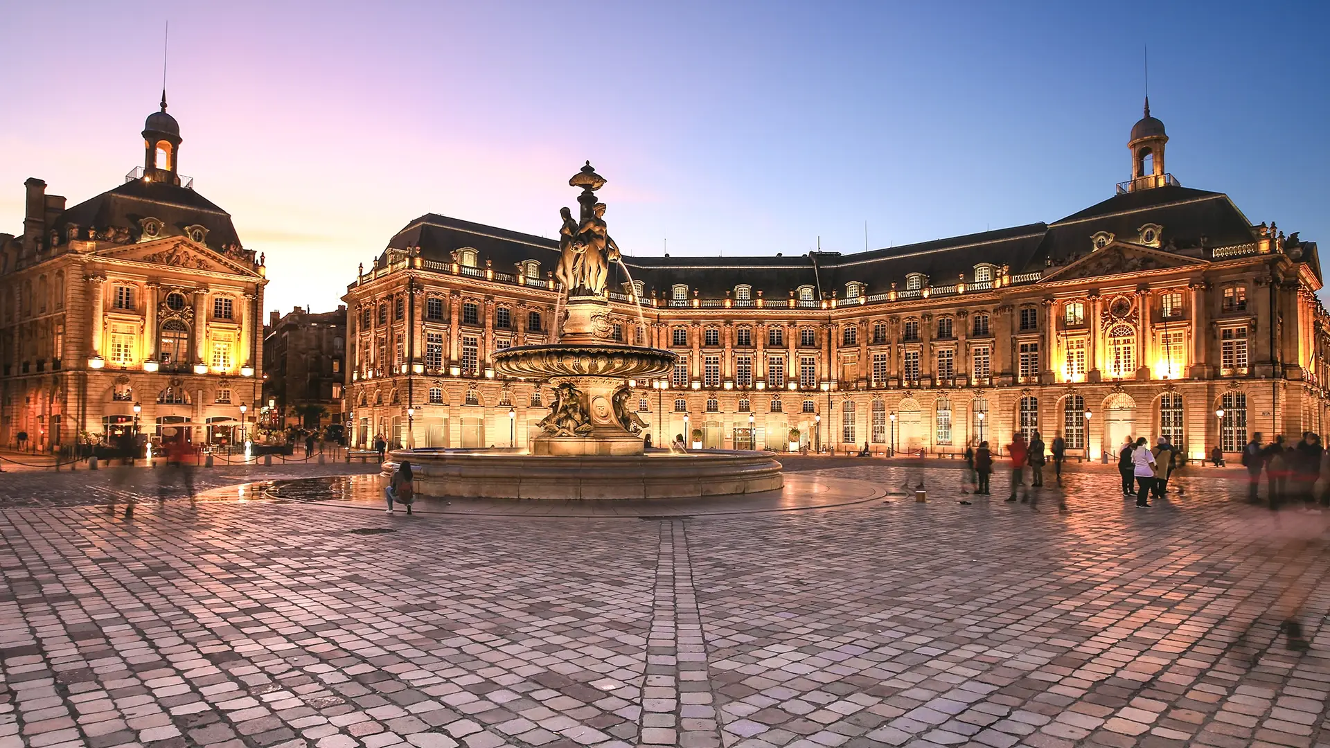 Vue du centre-ville de Bordeaux, proche du miroir d'eau, à la tombée de la nuit